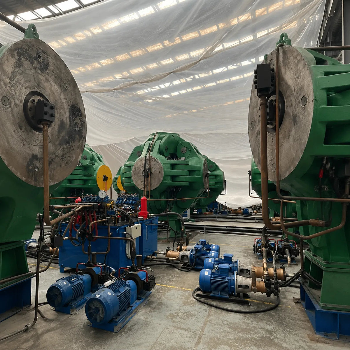 Large industrial machinery with green and blue components in a warehouse setting.