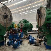 Large industrial machinery with green and blue components in a warehouse setting.