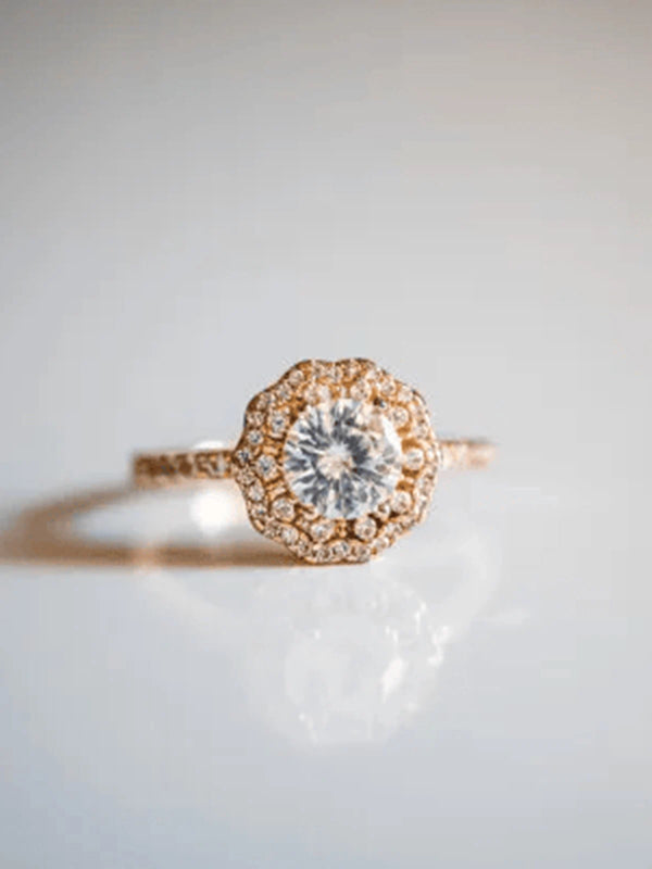 Rose gold ring with a diamond on a light gray background
