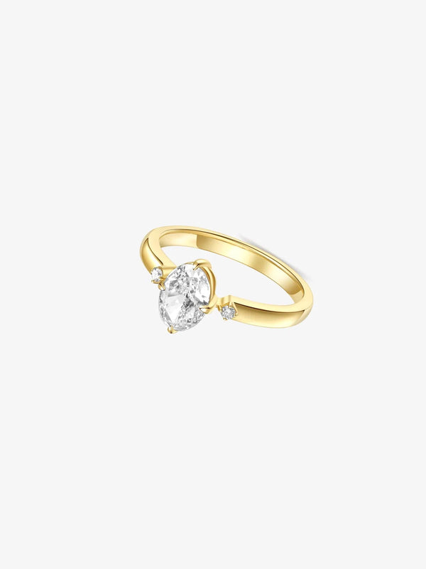 Gold ring with a pear-shaped diamond on a white background