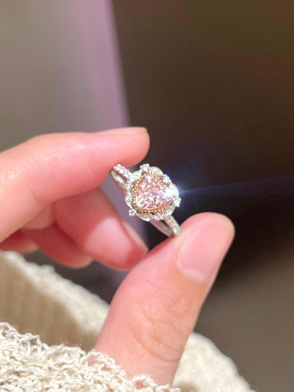Diamond ring held between fingers with a blurred background