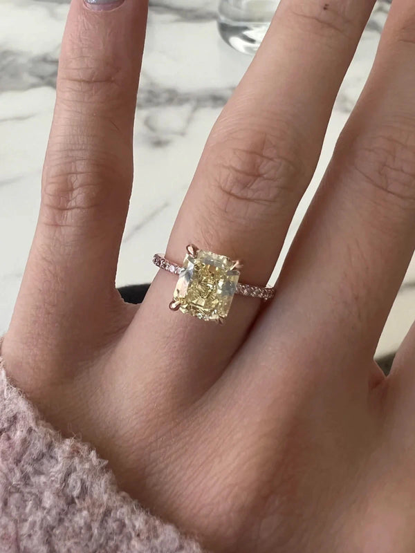 Close-up of a hand wearing a diamond ring on a marble surface