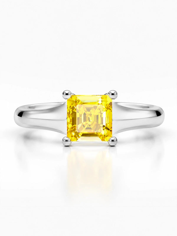 Ring with a yellow gemstone and silver setting on a white background